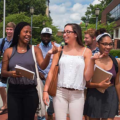 happy v.c.u. students walking together on campus on a sunny day