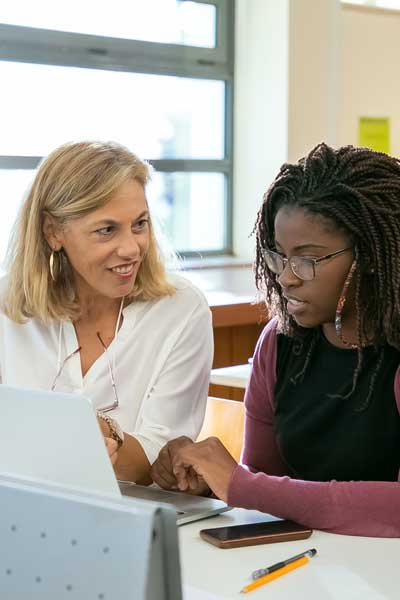 a professor assists a student with a computer assignment